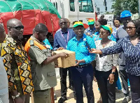 Ken Ofori-Atta (speaking through the microphone) presenting the donation to Volta flood victims