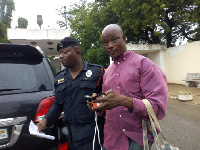 The suspect, Hamza Fuseini being led away by a police officer