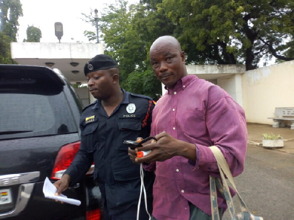 The suspect, Hamza Fuseini being led away by a police officer