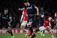 A photo of Thomas Partey challenging Declan Rice for a ball