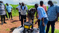 Executive Director of the Scheme, Hon. Mustapha Ussif with some officials in one of the maize farms