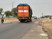 A tomato truck climbing a speed ramp without a road sign