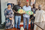 Alhaji Osuman (second left) displaying the titles with former President Mahama