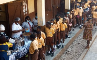 School children line up for school feeding meals