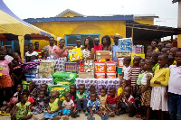 Nana Ama Mcbrown  with Maxwell, others presenting the items to Royal Seed Home and School