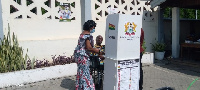 Prof George Benneh voting in front of the designated box for thumbprinting