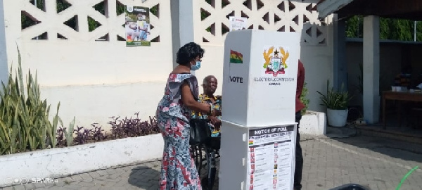 Prof George Benneh voting in front of the designated box for thumbprinting