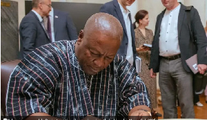 Mahama signs a copy of the Russian translation of his autobiography at the book launch in Moscow (J