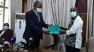 Justice Diawuo (L) submitting the report to Simon Osei Mensah