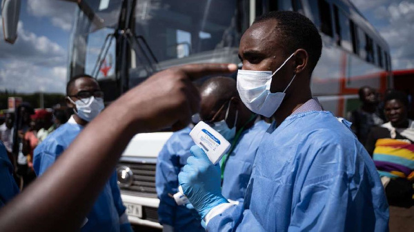 A staff of the Rwanda Biomedical Center (RBC) screens passengers at a bus station in Kigali,| AFP