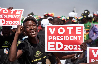 A ZANU-PF supporter holds a sign encouraging people to vote for President Emmerson Mnangagwa