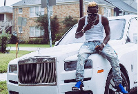 Shatta Wale sitting on the Rolls Royce