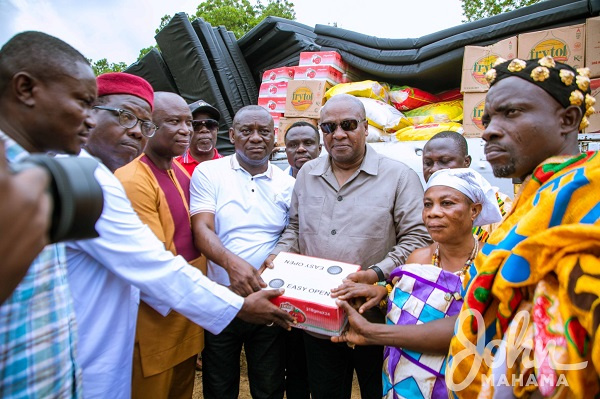 Ex-President Mahama (in dark shades) presenting relief items to leaders of leaders of Apiate