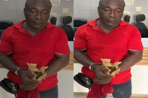 Apostle Kwabena Owusu Agyei holding a substance suspected to be marijuana