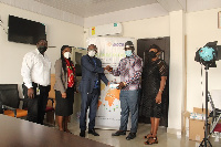 Jones Darmoe (left) presents items to David Amoateng (right)