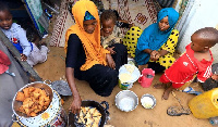 An internally displaced Somali woman and her children prepare Iftar meal during the month of Ramadan