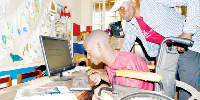 A child with special needs learns computer in Kampala, Uganda.