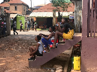 Melphia (left) sitting on the steps of Martin Opoku Sekyere