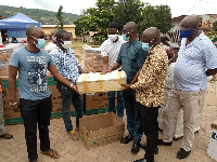 MCE for Lower Manya Krobo Municipality presenting the items to a beneficiary