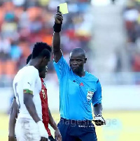 A Mozambican player booked after he hauled down John Boye