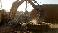 An excavator demolishing a mining pit