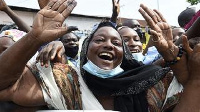 Supporters wave to incumbent Benin President Patrice Talon on his arrival to vote at the Zongo Ehuzu