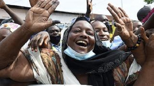 Supporters wave to incumbent Benin President Patrice Talon on his arrival to vote at the Zongo Ehuzu