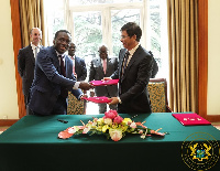 Akufo-Addo looks on as officials of both GNPC and China Harbour Eng. company exchange agreements