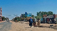 People walk along a deserted street in southern Khartoum