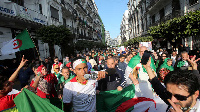 Demonstrators carry national flags as they march.