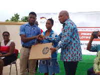 Okudzeto Ablakwa presenting a laptop to one of the beneficiaries