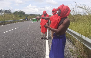 The Fetish priest pouring libation on the road