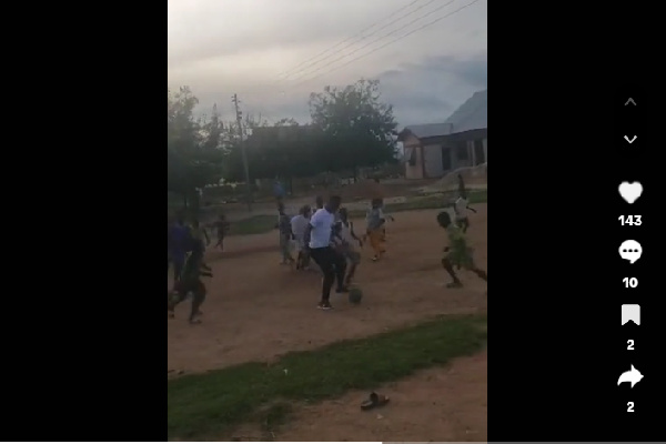 John Paintsil (in white) with the young footballers on the grassless pitch