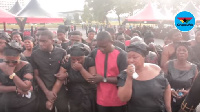 Valentina, wife of the late KABA escorted by two strong men to see her husband for the last time