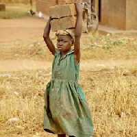 A child carrying cement blocks