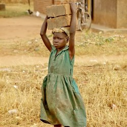 A child carrying cement blocks