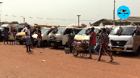 Some drivers and passengers walking about the Madina bus station