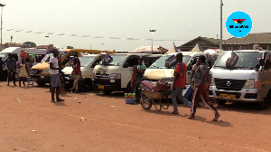 Some drivers and passengers walking about the Madina bus station