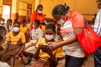 Legal, External Affairs Director of Vodafone Ghana, Geta Striggner-Quartey interacting with a pupil