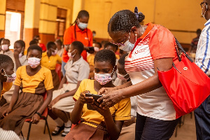 Legal, External Affairs Director of Vodafone Ghana, Geta Striggner-Quartey interacting with a pupil