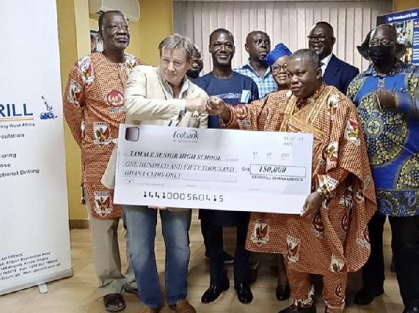 An official of Geodril (second left) presents the cheque to a TAMASCAN old student