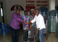 John Kudalor presenting plastic chairs to the Central Regional NDC