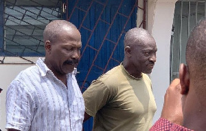 Col. Samuel K. Gameli (left) and Gershon Akpa being escorted from the court