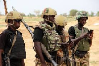 Nigerian Army soldiers are seen driving on a military vehicle in Ngamdu