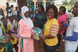 Amel Nancy Dery presenting the sanitary kit and educational materials to a beneficiary