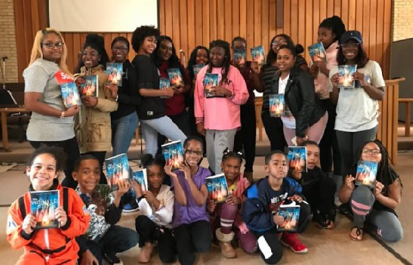 Havana Chapman-Edwards (kneeling extreme left) with friends holding the book 