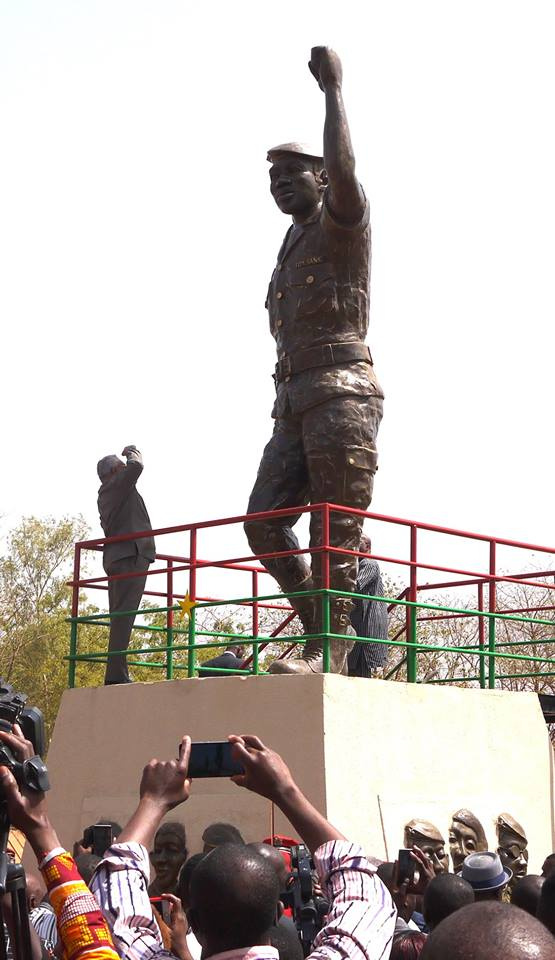 JJ Rawlings standing in front of Thomas Sankara statue