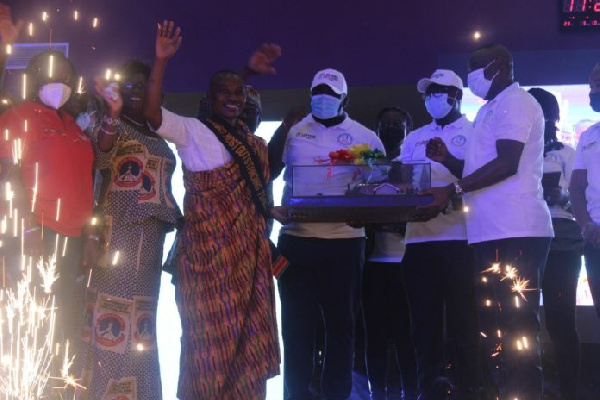 Ebenezer Kojo Otu (in kente) receives a prototype of his three-bedroom building