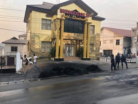 Angry customers of Menzgold burn tyres at building entrance