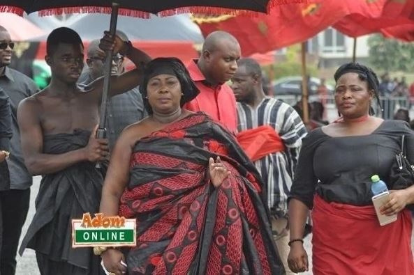 Oheneyere Gifty Anti being accompanied with an umbrella